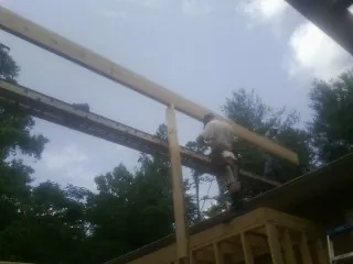 Carpenter setting a ridge beam over a new addition frame — Ice Dam Removal by Roofing Brothers in Pawcatuck