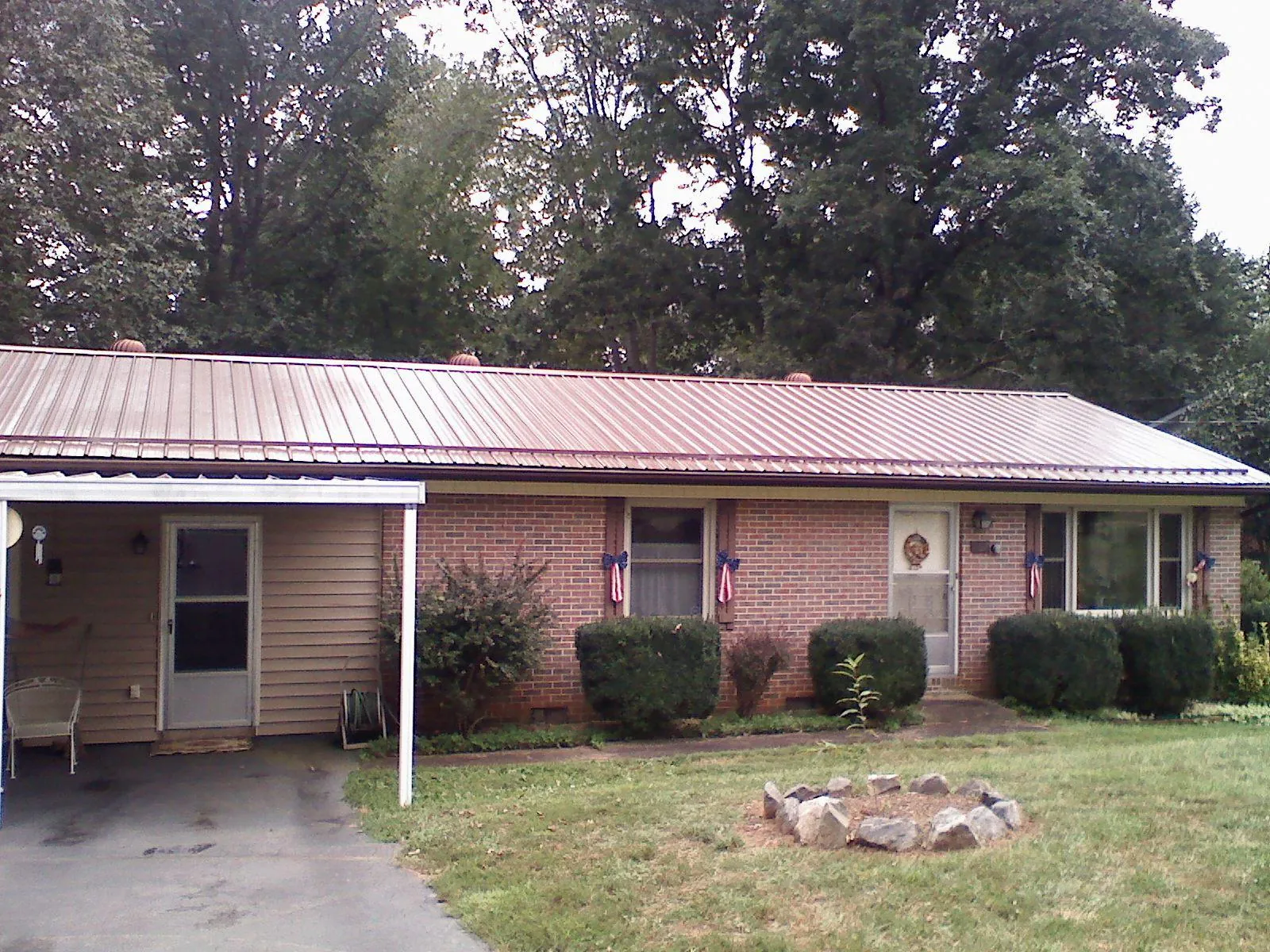 Bronze metal roof and carport on a brick ranch home — Roof Repair work by our crew in Pawcatuck